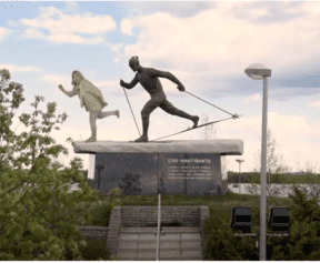 a statue and a person showing how to skiing